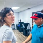 Vibrant indoor salsa dance class at Salsa Dallas with students practicing dance moves and instructor guiding; lively atmosphere, mirrored walls, and dance floor.