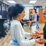 Salsa Dallas dance class with couples practicing salsa steps and socializing at the studio.
