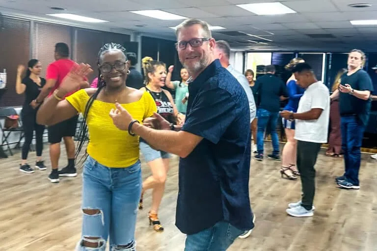 Lively scene of diverse people dancing and enjoying salsa lessons at Salsa Dallas, showcasing fun, social interaction, and a vibrant dance community in a modern indoor studio.