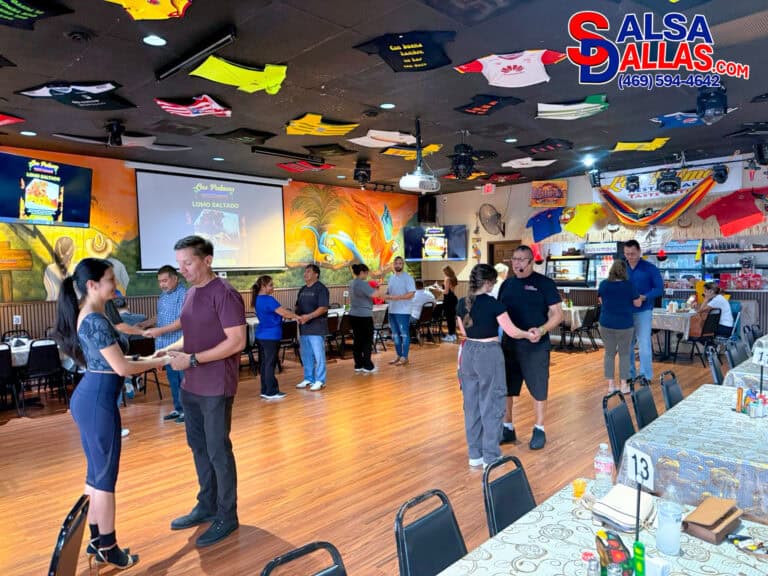 Dance class at Salsa Dallas promoting salsa lessons and dance events in Dallas, Texas, with couples practicing salsa steps and enjoying a lively, colorful atmosphere.